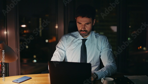 Confused entrepreneur looking laptop monitor sitting office late evening closeup