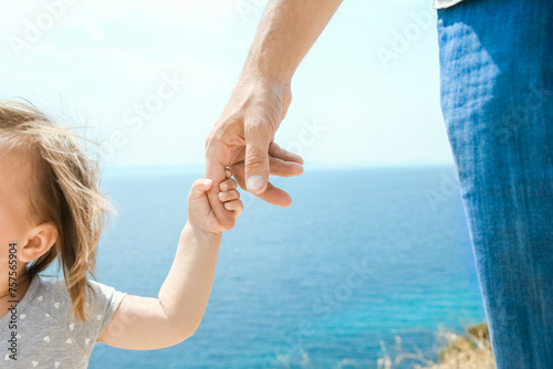 A hands of happy parents and children at sea in travel background in greece