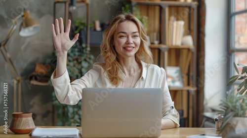 Head shot happy young 30s woman sitting at wooden desk, looking at camera, waving hello. Excited businesswoman teacher lecturer recording educational video,