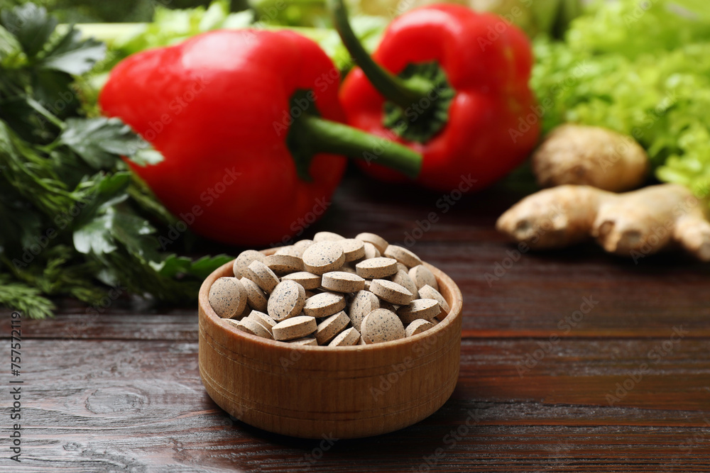 Dietary supplements. Pills in bowl and food products on wooden table Dietary supplements. Pills in bowl and food products on wooden table