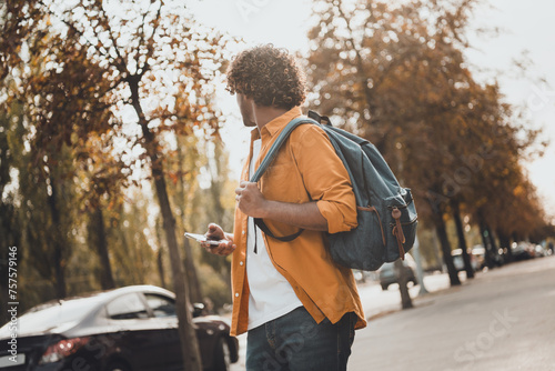 Photo of young hispanic man traveler tourist walking and exploring city using phone google map gps navigation