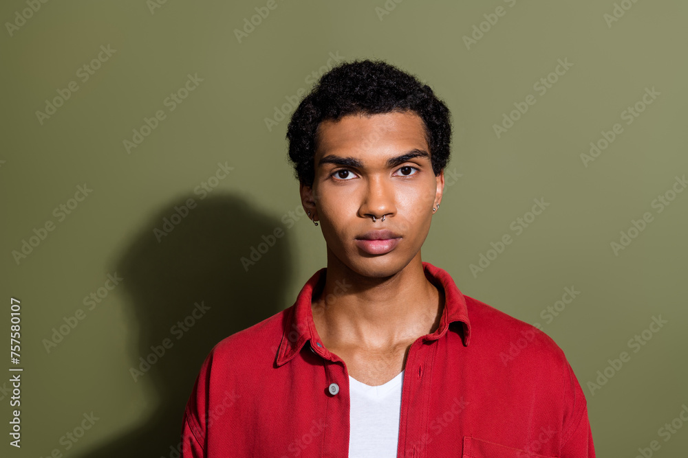 Photo of cool serious guy wear red shirt looking you empty space isolated khaki color background Photo of cool serious guy wear red shirt looking you empty space isolated khaki color background