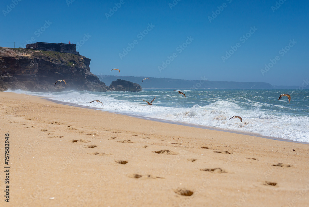 North Beach famous for giant waves in Nazare town on so called Silver Coast, Oeste region of Portugal, view with fort of Saint Michael the Archangel