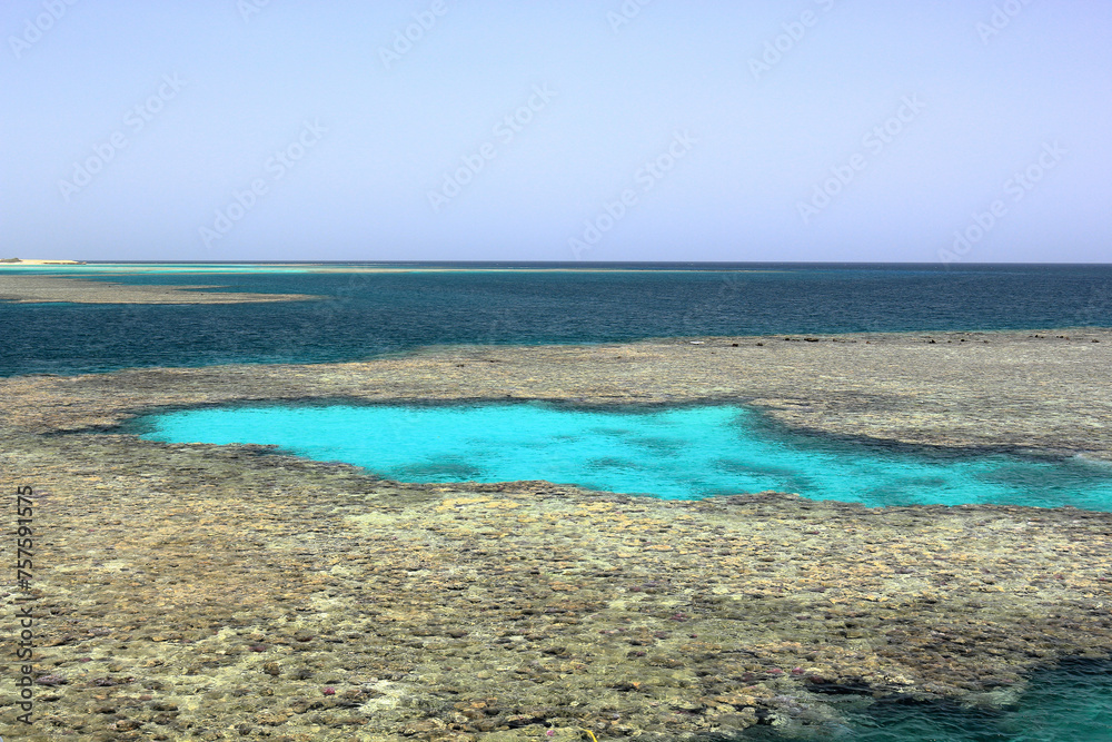 Captivating view of Egypt's Red Sea coral reef near Marsa Alam, Hamata Islands. Crystal-clear turquoise waters under a warm, sunny sky.