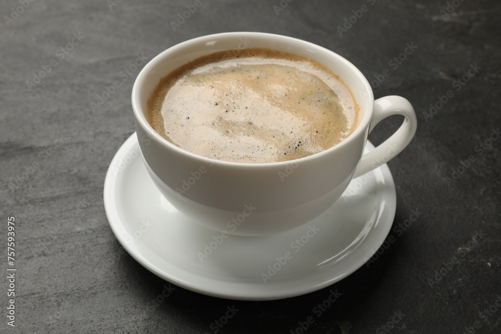 Cup of aromatic coffee on black table, closeup Cup of aromatic coffee on black table, closeup