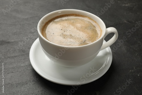 Cup of aromatic coffee on black table, closeup