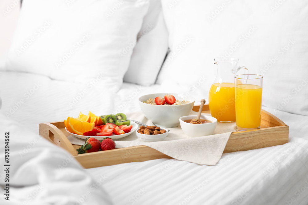 Wooden tray with tasty breakfast on bed Wooden tray with tasty breakfast on bed