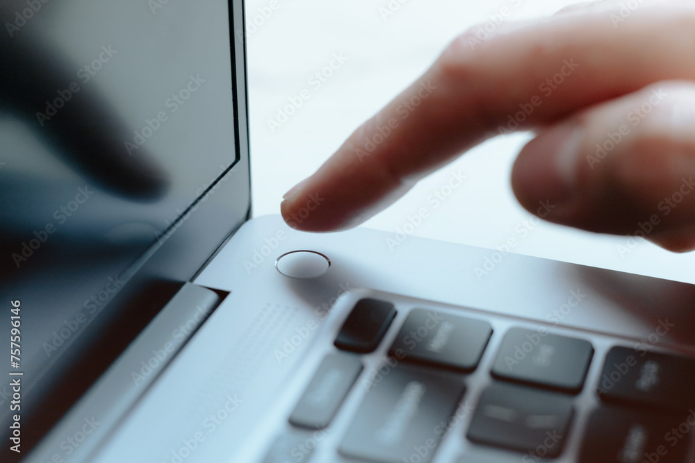 Man touching Laptop fingerprint reader. Scan finger to log into account. Access