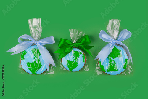 Earth Day concept. Сookies in shape of Earth on green backdrop.