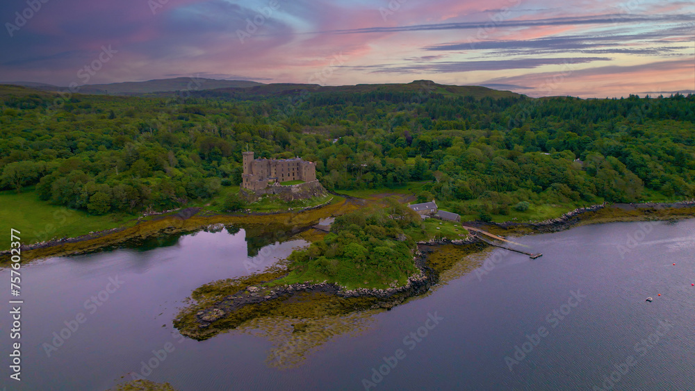 AERIAL: Medieval Dunvegan Castle built on an elevated rock overlooking sea loch
