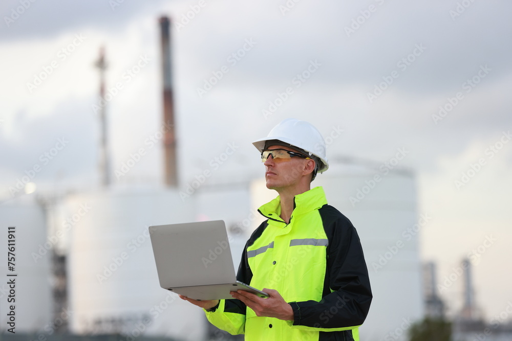 engineer wearing a green safety jacket holding a laptop working at the front construction, engineering, and technology engineer wearing a green safety jacket holding a laptop working at the front construction, engineering, and technology