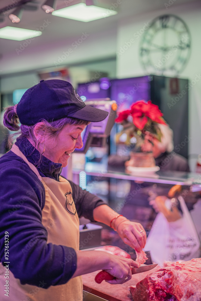 vertical portrait Smiling Female Butcher Cutting Meat for Customer in Butcher Shop