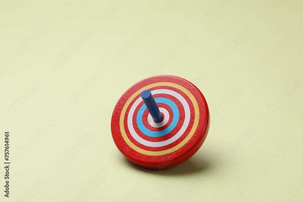 One colorful spinning top on green background One colorful spinning top on green background