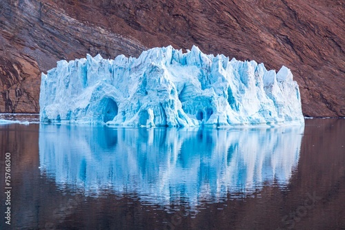 Iceberg in front of rock in fjord, Kaiser-Franz-Joseph-Fjord, east coast Greenland, Denmark, Europe photo