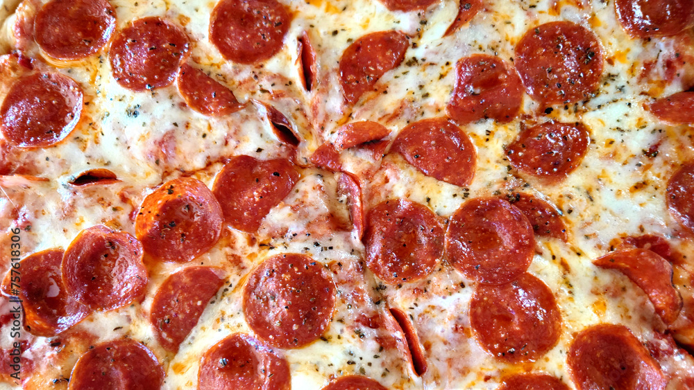 a closeup of the surface of a pepperoni pizza with lots of pepperoni a closeup of the surface of a pepperoni pizza with lots of pepperoni