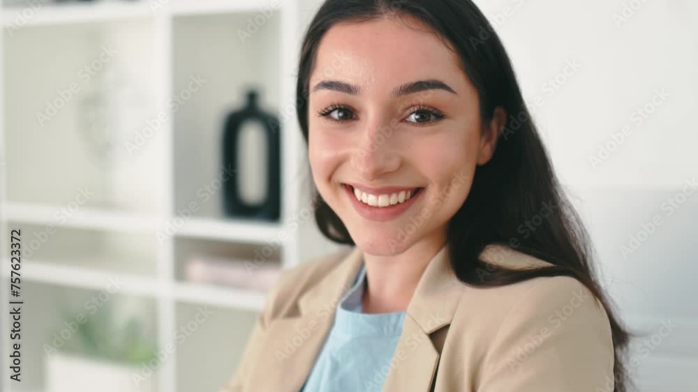 Positive gorgeous arabian or indian brunette business lady in elegant clothes, company employee, lawyer, ceo, sits at workplace in modern office, looks at camera, smiling friendly Positive gorgeous arabian or indian brunette business lady in elegant clothes, company employee, lawyer, ceo, sits at workplace in modern office, looks at camera, smiling friendly
