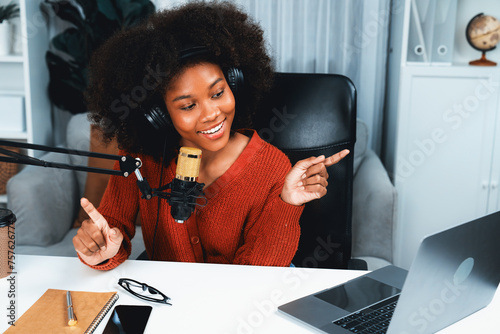 Host channel of beautiful African woman influencer talking with new listeners in broadcast studio. Time slot of life coach consultant on live social media online. Concept of giving advice. Tastemaker. photo