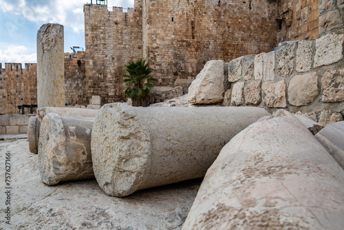 Dramatic image of fallen stone columns in front of old Jerusalem city walls, destroyed by the Roman’s in first century.