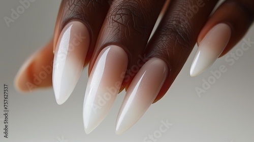 Female hands with long nails and a bottle of nude nail polish. photo