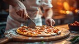 Chef slicing pizza on wooden board in kitchen.