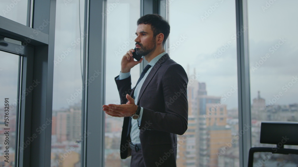 Business manager speaking cellphone looking at window office. Man calling phone. Business manager speaking cellphone looking at window office. Man calling phone.