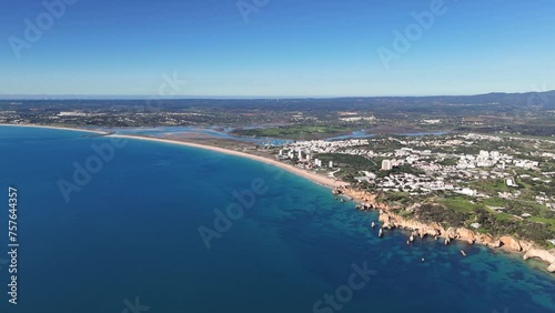 Wide angle drone footage of the Portuguese coastline showing Alvor and Portimao with mountains in the background