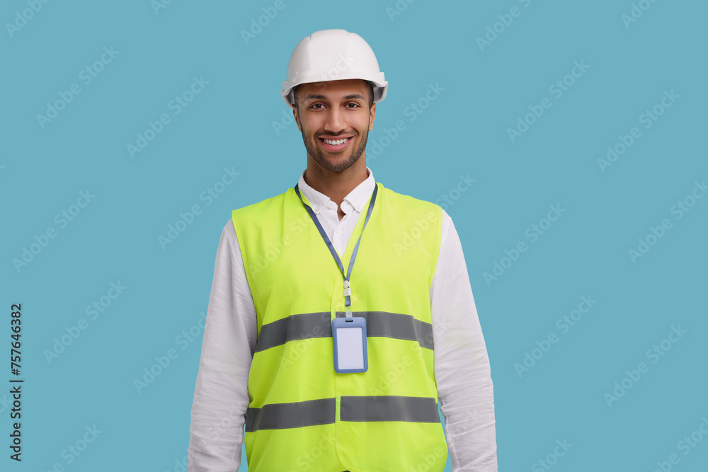 Engineer with hard hat and badge on light blue background
