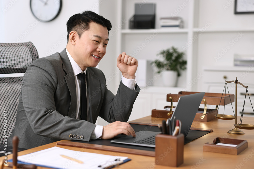 Notary working with laptop at wooden table in office Notary working with laptop at wooden table in office