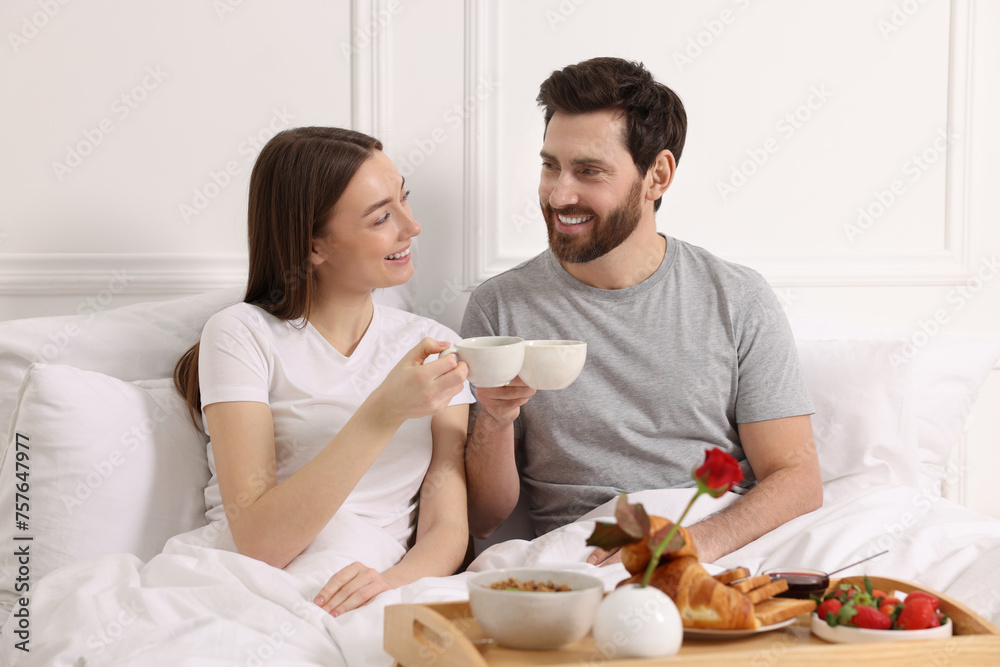 Happy couple having tasty breakfast in bed at home Happy couple having tasty breakfast in bed at home