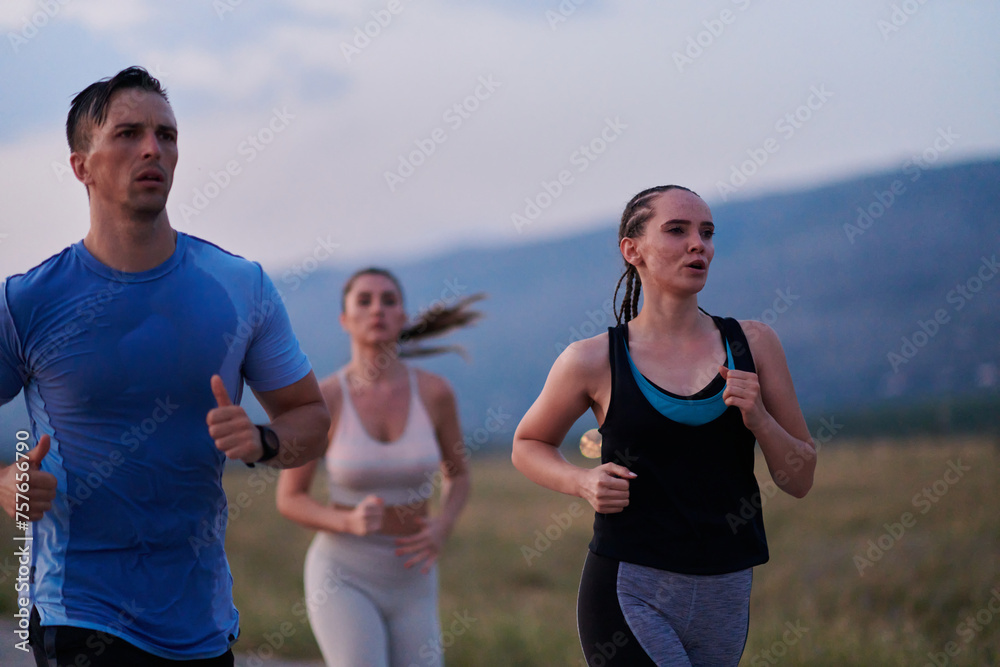 A diverse group of runners trains together at sunset. A diverse group of runners trains together at sunset.