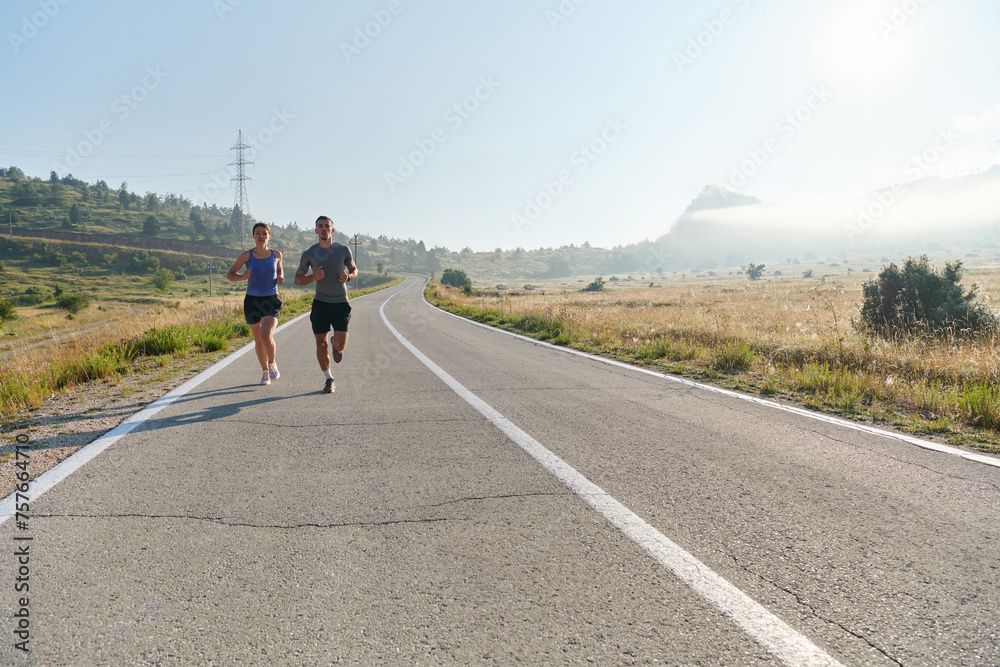 Fototapeta premium Energized by the beauty of nature, a couple powers through their morning run, their bodies and spirits invigorated.