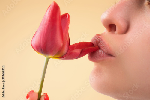 Tenderness tulip. Tender natural lips with tulips. Tenderness sexy woman mouth. Caring and tenderness. Close-up beautiful tender lips with tulips flower. Spa and cosmetics. Tenderness touch.