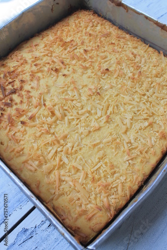 Indonesian food called prol tape sprinkled with cheese in a baking dish on the table photo