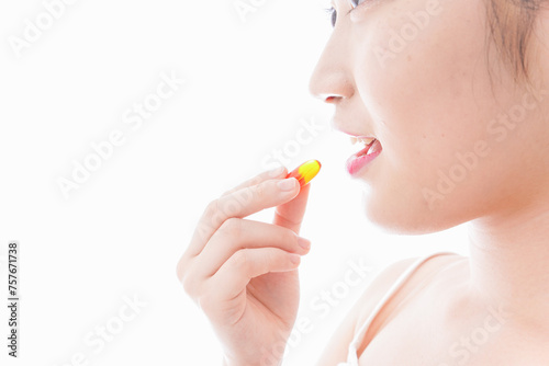 薬・サプリメントを飲む若い女性