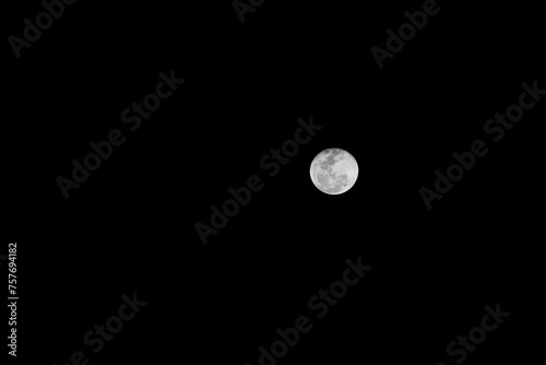 Bright full moon in dark night sky