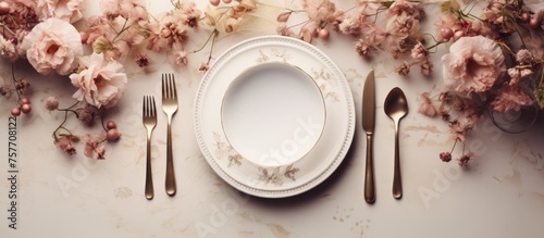 An elegant display of tableware, with a white porcelain plate, silver cutlery, and fresh flowers set on a table adorned with a tablecloth. Perfect for a special event or luxurious dining experience