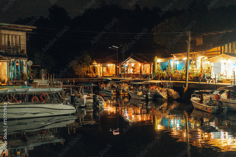 Night fishing village, boats in the canal by the sea