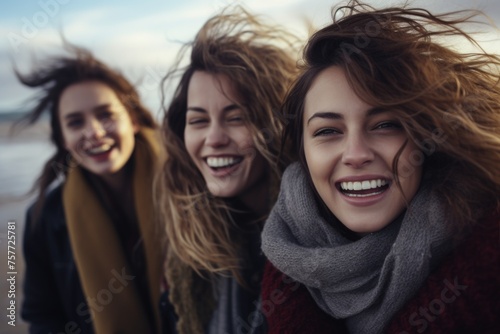 Three women with long hair are smiling and laughing together