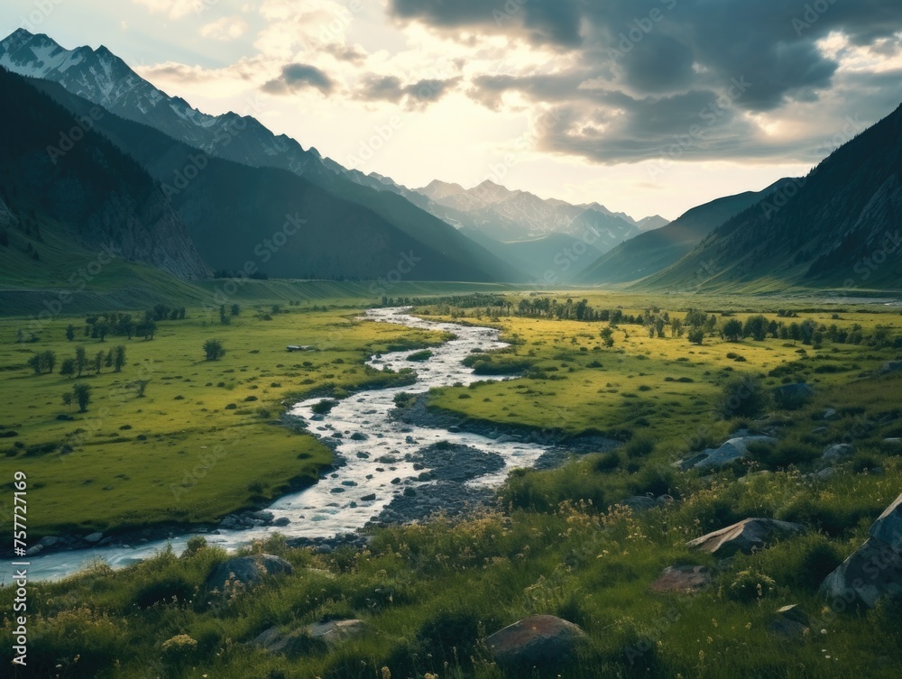 River flows through grassy valley with mountains in background