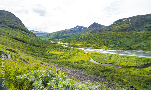 A beautiful Rapa river Rapadalen landscape with native plants. A mountain river from above in Sarek National Park, Sweden. Summer sceney of Northern Europe. photo