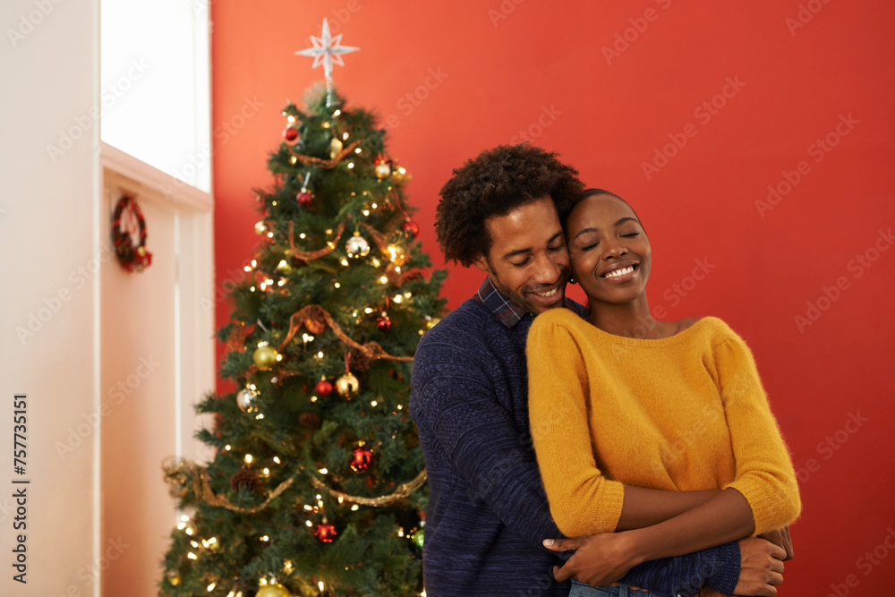 Couple, Christmas tree and festive holiday in house with happiness fr vacation celebration, gifts or bonding. Man, woman and smile with lighting decoration for winter season event, together or lounge
