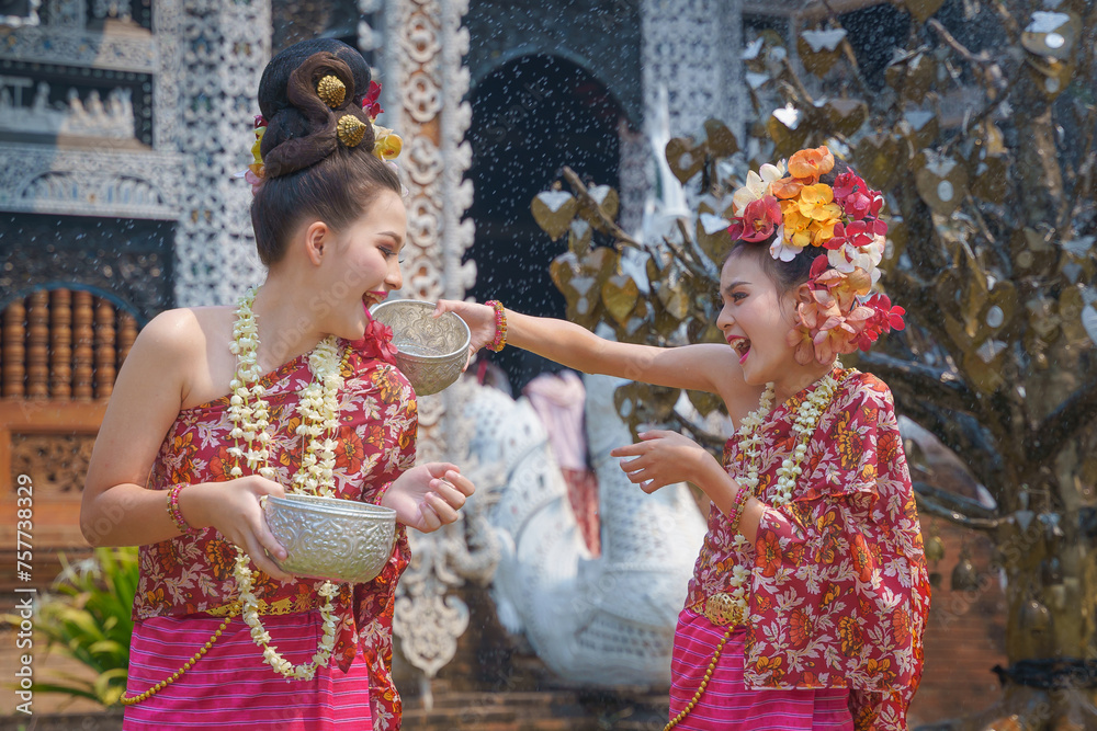 Obraz premium Pretty Asian women playing with water-splashing Songkran. Beautiful Thai traditional dress costumes according to Thai culture to celebrate the Songkran festival.