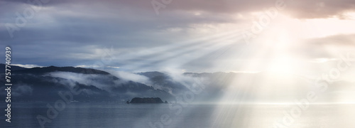 Sun rays  sea and clouds in blue sky with mountains  water and fog in evening. Lake  landscape and environment for holiday in summer  travel and destination for vacation or peace with scenery