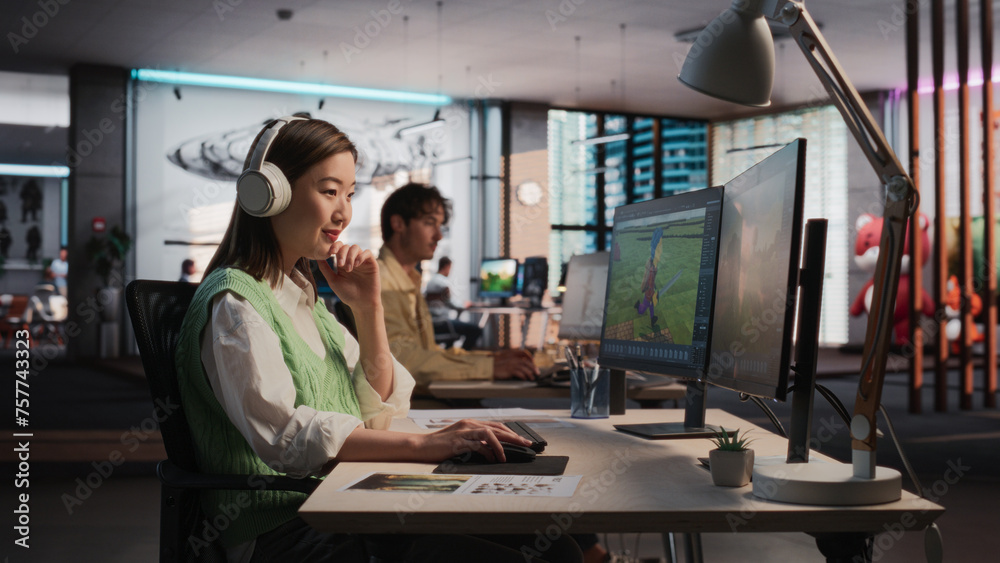 Female Asian Game Designer Using Desktop Computer, Designing Unique World And Characters In 3D modelling Software For RPG Video Game. Woman Working In Diverse Game Development Studio Office Female Asian Game Designer Using Desktop Computer, Designing Unique World And Characters In 3D modelling Software For RPG Video Game. Woman Working In Diverse Game Development Studio Office