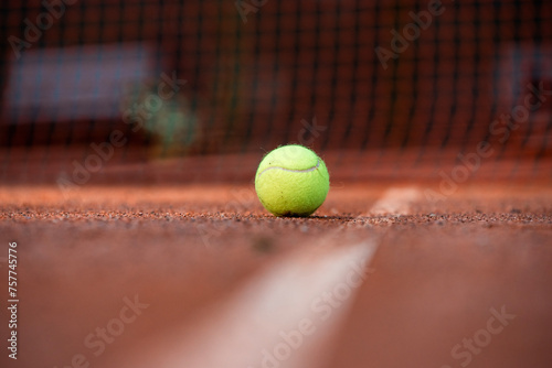 tennis ball on a clay court © Iliya Mitskavets