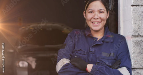 Image of glowing light over caucasian female car mechanic in workshop