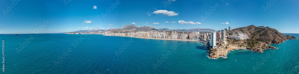 Extremely wide aerial drone photo of the norther part of Benidorm in Spain showing the Cala Almadraba Beach and the main Llevant beach on a sunny day in the summer time.