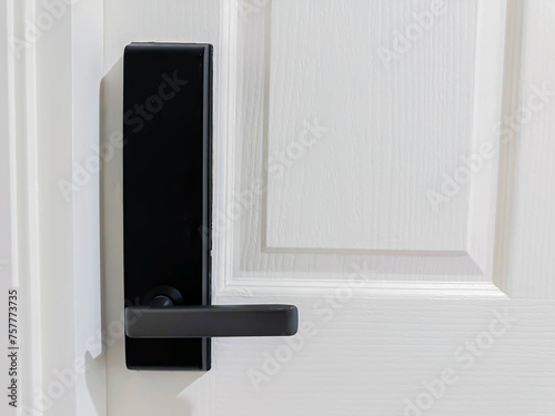 Closeup of black digital door lock handle on  white wooden door photo