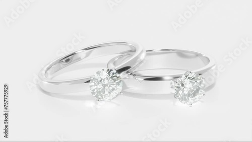 Two Platinum diamond rings rotating on white background from 3D animation design. 3d render.