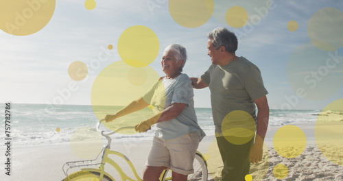 Senior biracial couple enjoys a sunny beach day, with copy space